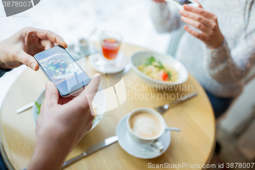 Image of close up of couple picturing food by smartphone