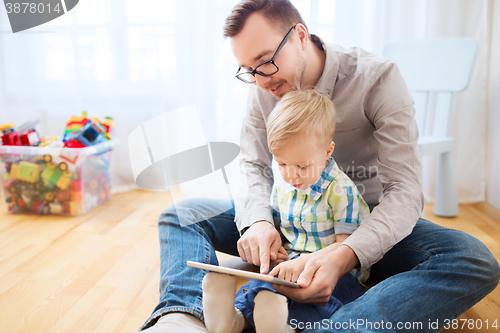 Image of father and son with tablet pc playing at home