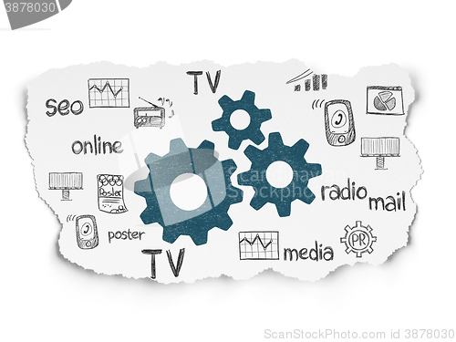 Image of Advertising concept: Gears on Torn Paper background