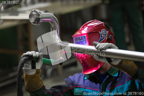 Image of Industrial worker welding in metal factory.