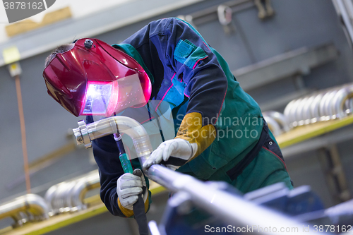 Image of Industrial worker welding in metal factory.