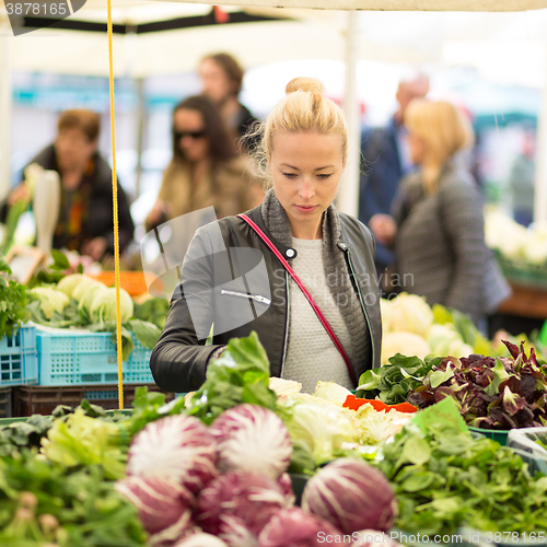 Image of Woman buying vegetable at local food market. 