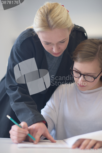 Image of female teacher helping students on class