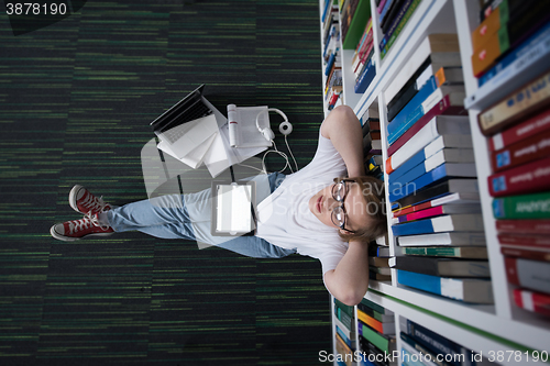 Image of female student study in library, using tablet and searching for 