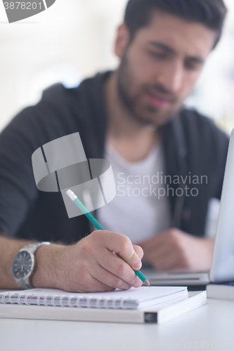 Image of student in school library using laptop for research