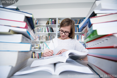 Image of female student study in library, using tablet and searching for 