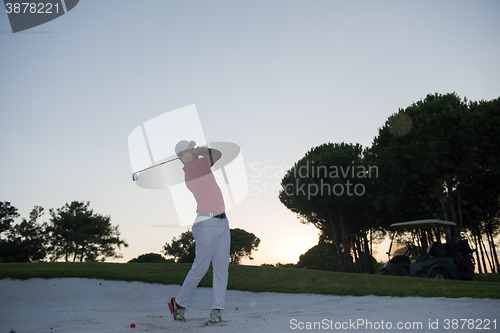 Image of golfer hitting a sand bunker shot on sunset