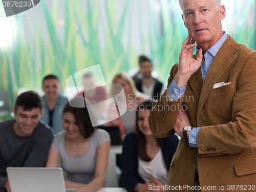 Image of portrait of in teacher in classroom with students group in backg