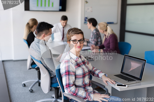 Image of young business woman at office working on laptop with team on me