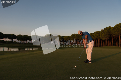 Image of golfer  hitting shot at golf course