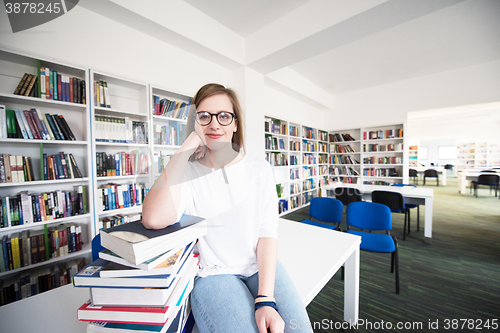 Image of female student study in library, using tablet and searching for 