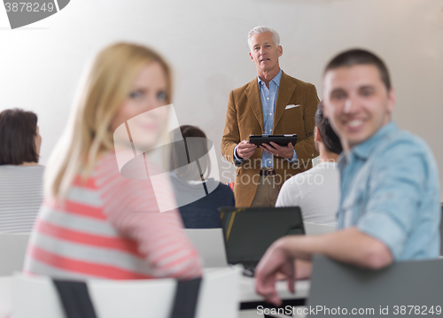 Image of teacher with a group of students in classroom