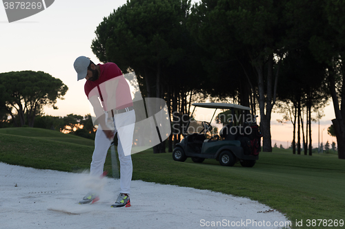 Image of golfer hitting a sand bunker shot on sunset