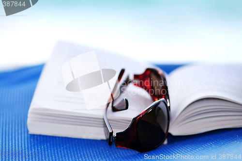 Image of Sunglasses and book on beach chair