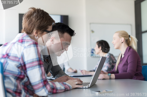 Image of young business couple working on laptop, businesspeople group on