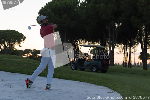 Image of golfer hitting a sand bunker shot on sunset