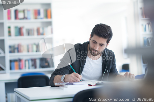 Image of student in school library using laptop for research