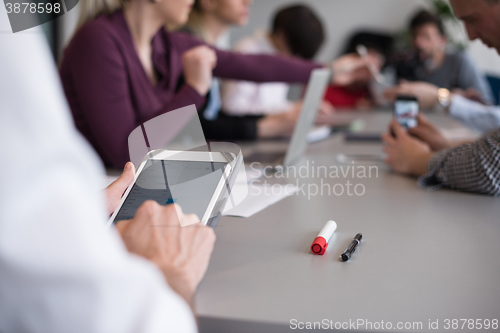 Image of close up of  businessman hands  using tablet on meeting