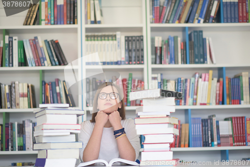 Image of female student study in library, using tablet and searching for 