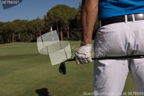 Image of golf player close up hand and driver from back