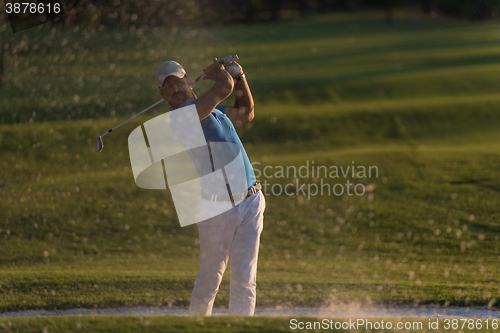 Image of golfer hitting a sand bunker shot on sunset