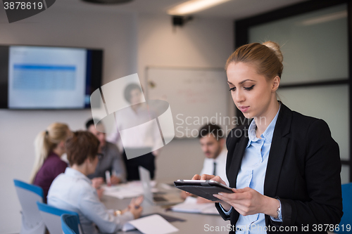 Image of business woman working on tablet at meeting room