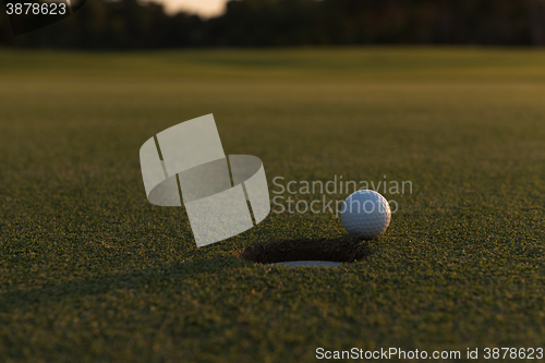 Image of golf ball on edge of  the hole