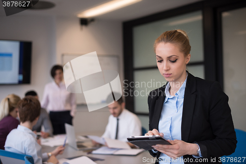 Image of business woman working on tablet at meeting room