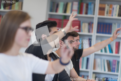 Image of group of students  raise hands up