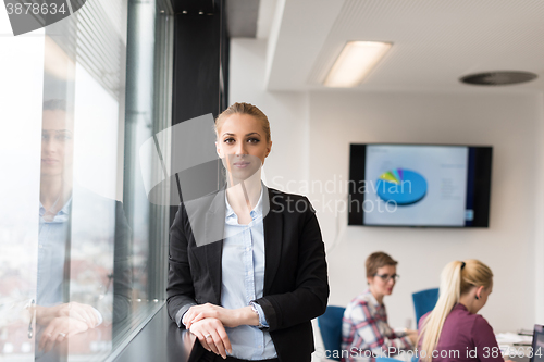 Image of portrait of young business woman at office with team on meeting 