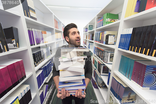 Image of Student holding lot of books in school library