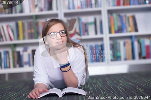 Image of female student study in library, using tablet and searching for 