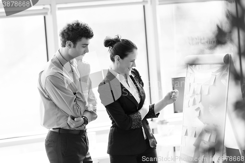 Image of young couple working together and taking notes on flip board at 