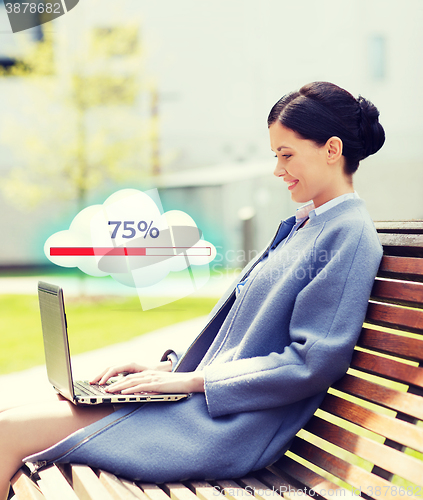 Image of smiling business woman with laptop in city