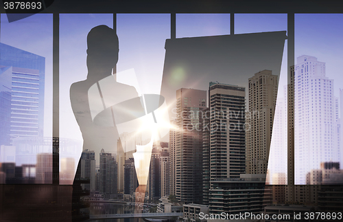 Image of silhouette of woman with flipboard over city