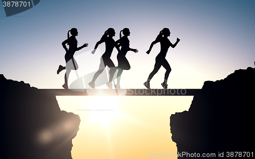 Image of happy young sports woman running outdoors