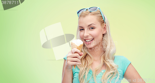 Image of happy young woman in sunglasses eating ice cream