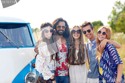Image of smiling young hippie friends over minivan car