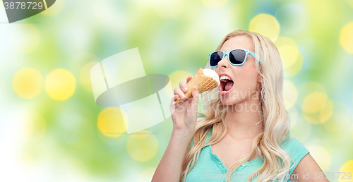 Image of happy young woman in sunglasses eating ice cream