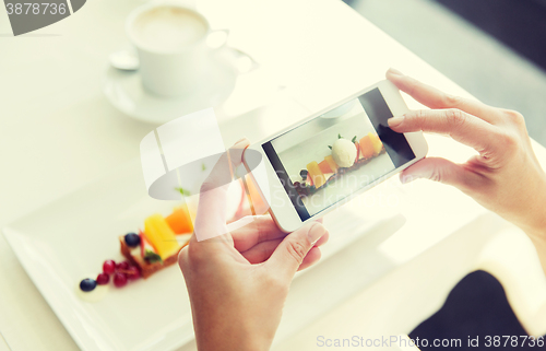 Image of close up of woman picturing food by smartphone