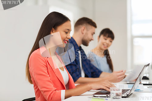 Image of happy african woman over creative team at office