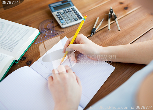 Image of close up of hands with ruler and pencil drawing