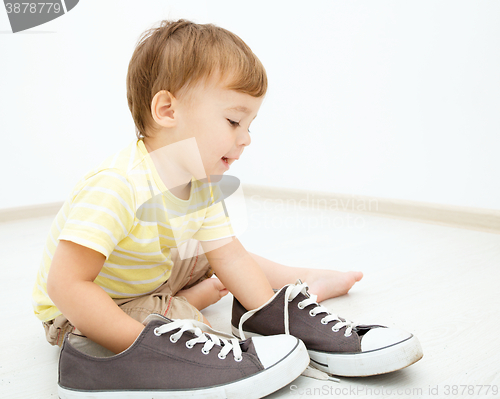 Image of Boy is playing with big sneakers