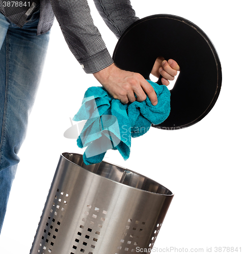 Image of Young man putting a dirty towel in a laundry basket