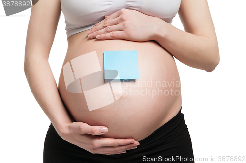 Image of Pregnant woman holding belly with arms 