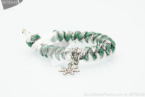 Image of green braided bracelet on white background. snowflake