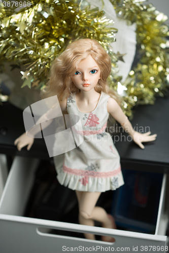 Image of doll in a box on a light background. blurred rear plan