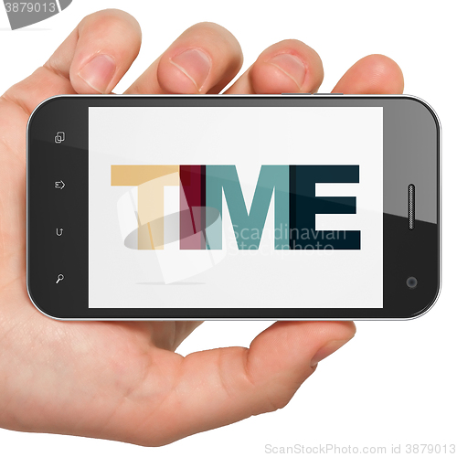 Image of Time concept: Hand Holding Smartphone with Time on  display