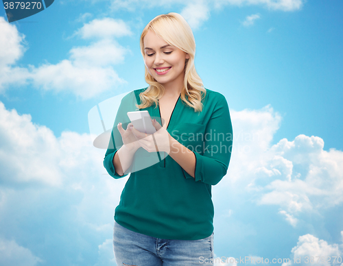 Image of happy woman with smartphone texting message