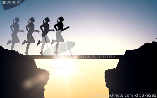 Image of happy young sports woman running outdoors